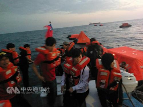 图为海巡队将乘坐救生艇的游客救上巡防艇。